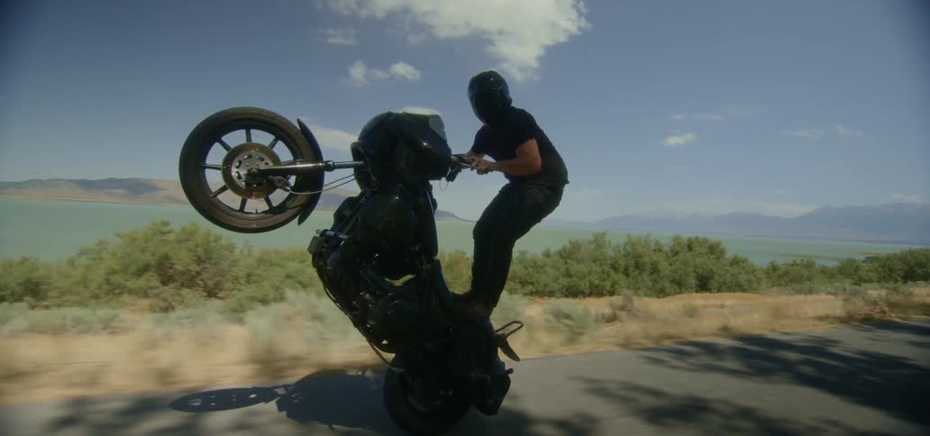 A man does a wheelie on a motorcycle