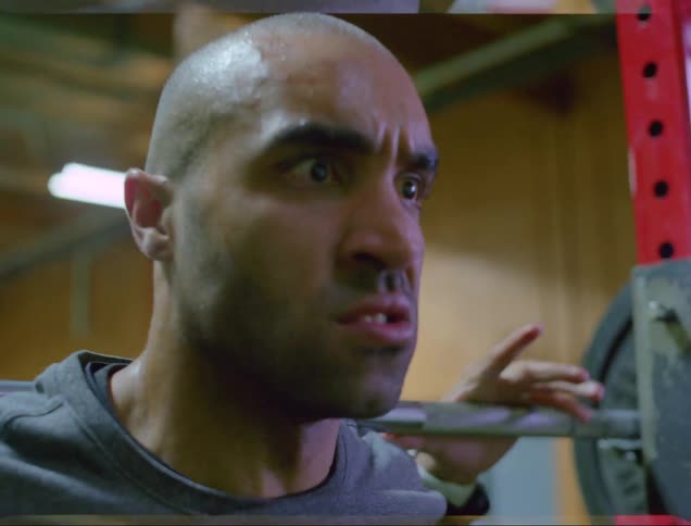 A man is lifting weights in a gym