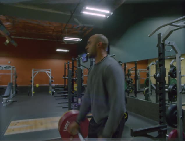 Man lifts heavy weight then drops it in colorful gym
