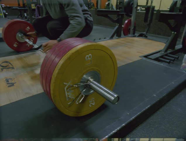 A man is lifting weights in a gym