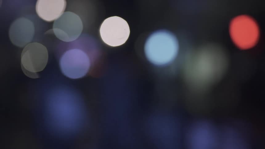 A shadow is moving in between blurry lights