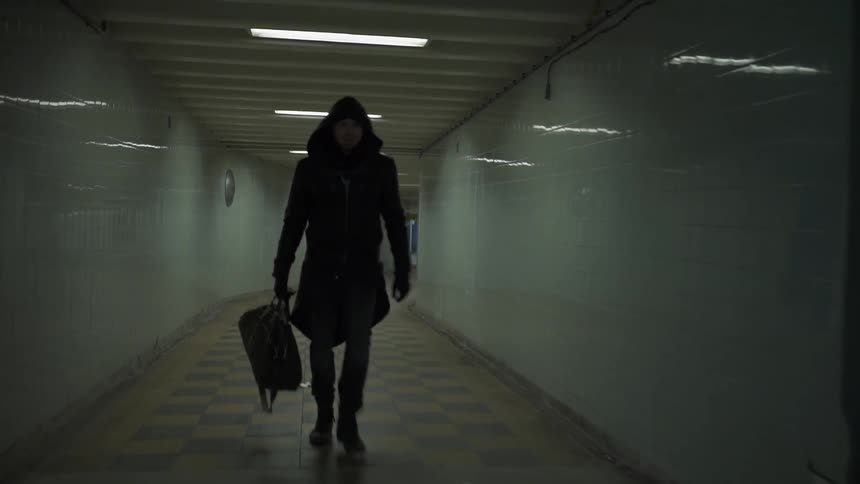 A man walks down a long hall