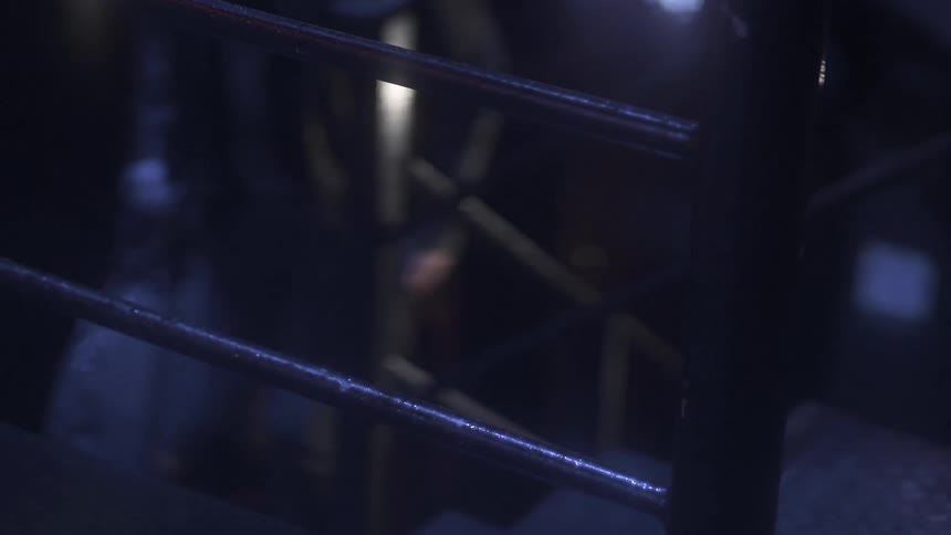 A man walks up some steps in the dark