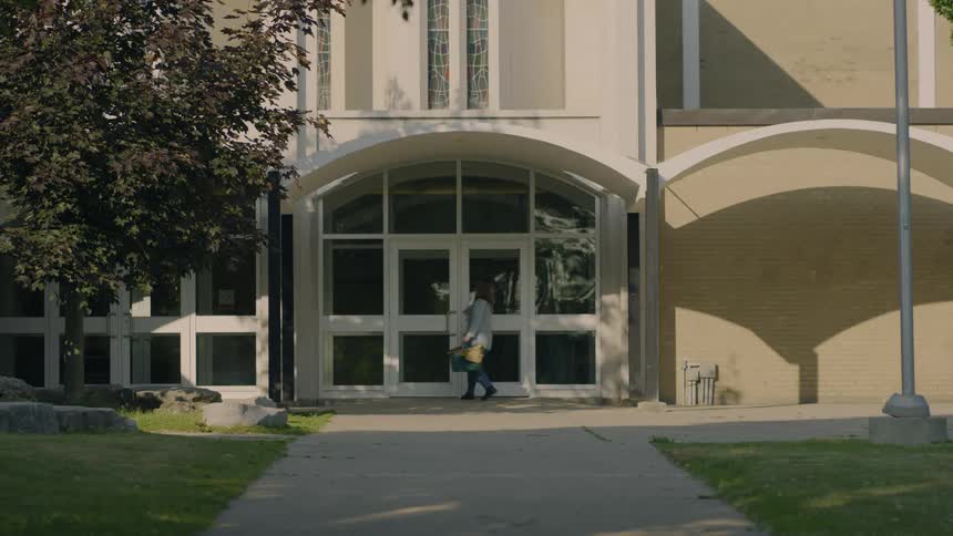 Woman opens a door to enter a building at morning