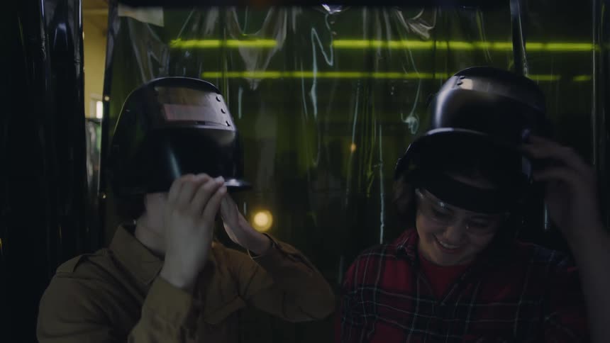 Boy and girl wears welding helmets