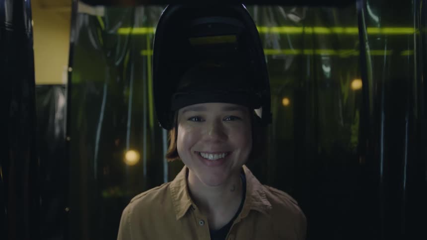 Woman removing a helmet and smiling indoors