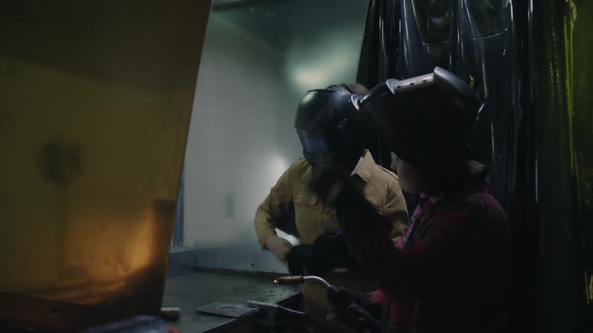 Teacher congratulates a student after a great welding job in the workshop