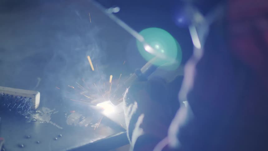 A person welding something and several sparks flying