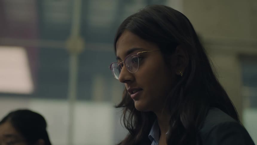 Young woman wearing glasses tilts her head