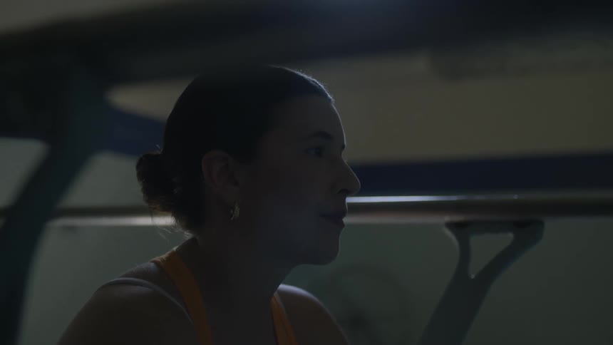 A woman sits near a pool while focusing her attention on others