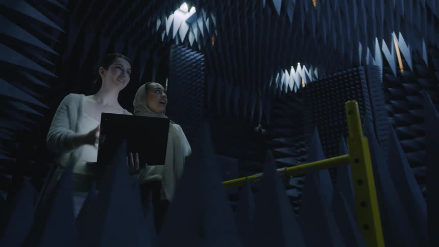 Two women setting up a stage lightening system with a computer