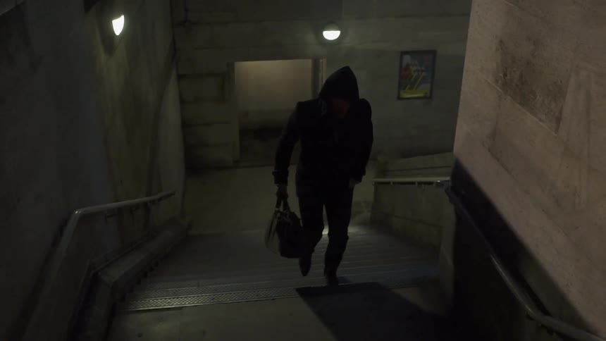 A man looks over his shoulder as he ascends a stairwell