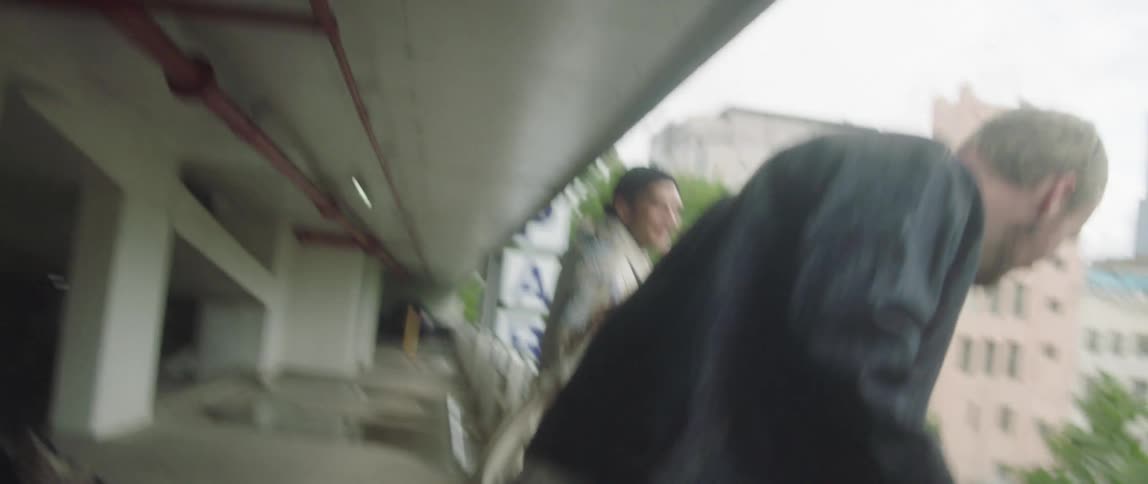 Four people walking in a parking garage look over the edge and go about their way