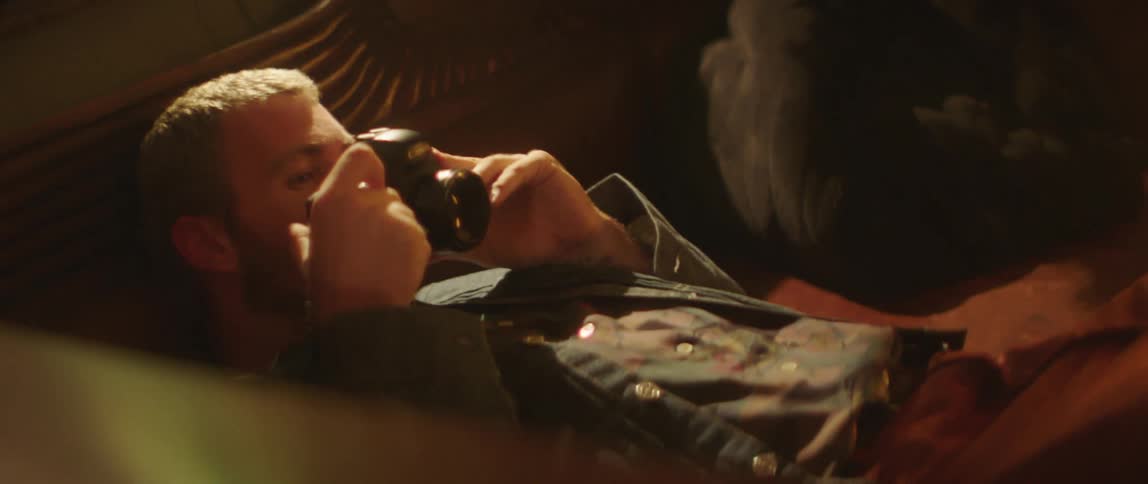Man lies on his back looking through his camera viewfinder