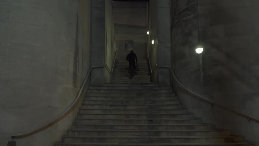 A man climbs up steps into a building