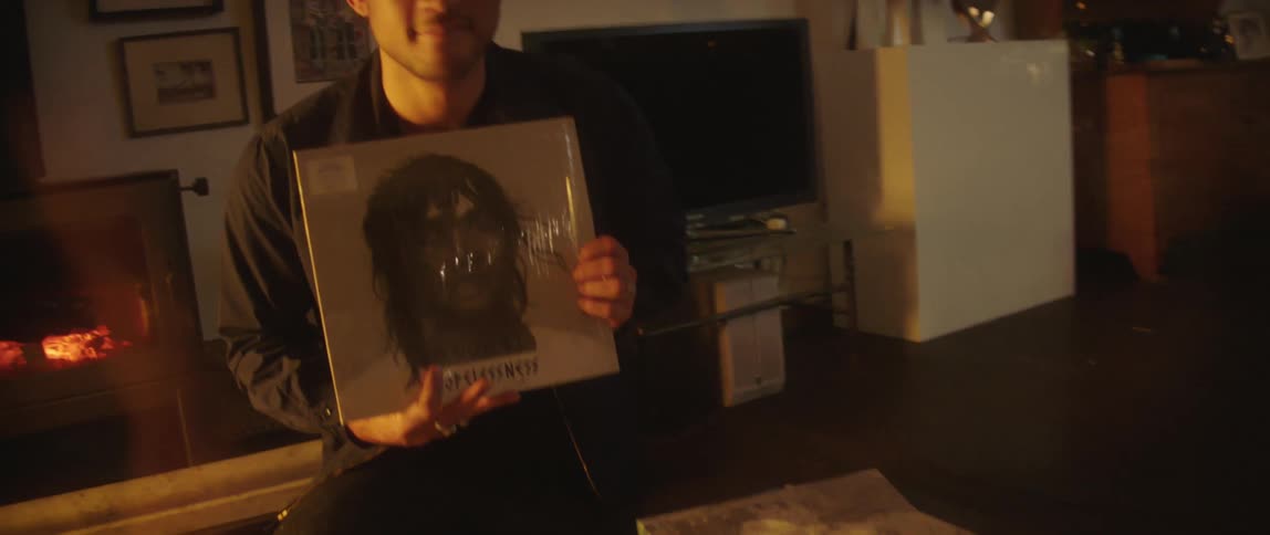 A man shows off his records at home