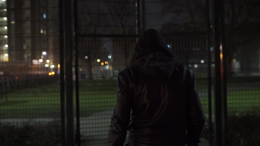 A man walks and opens a gate