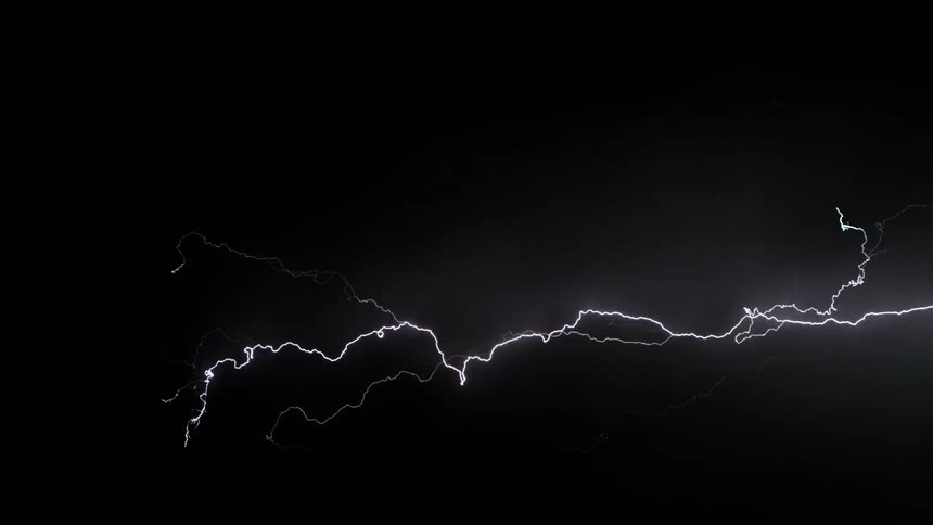Lightning bolts wind through sky at night illuminating clouds during the flashes