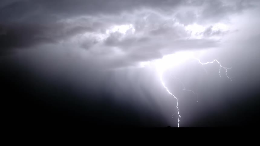 Streaks of lightning streak throughout a stormy sky at night
