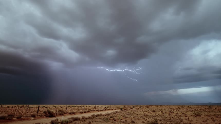 Storm clouds shoot lightning in the desert