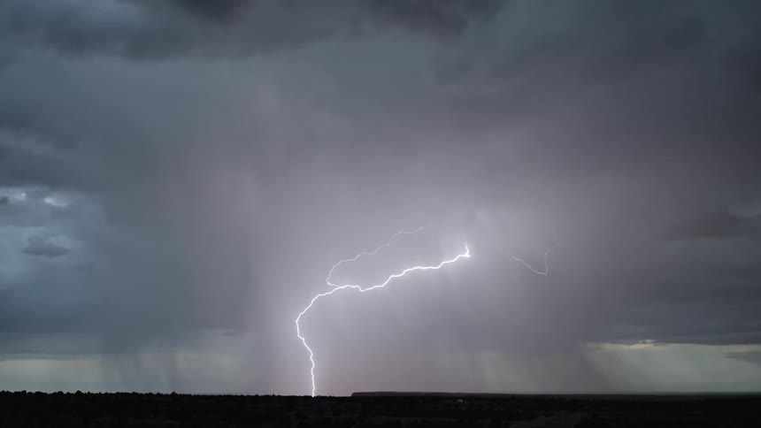 A thunderstorm raging in the evening concealed within a thick cloud creating a dramatic and powerful natural spectacle