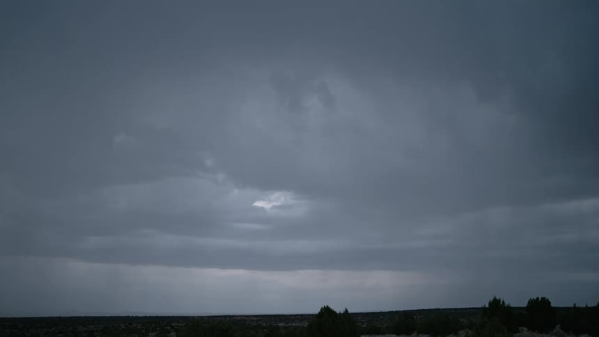 Bolts of lightning streak through the sky above a grassland in the evening