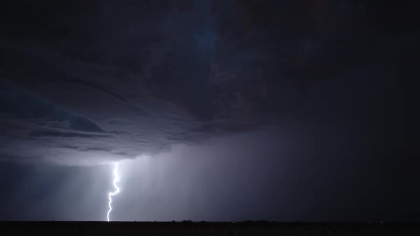 Bright bolts of lightning illuminate a stormy sky in the dark of night