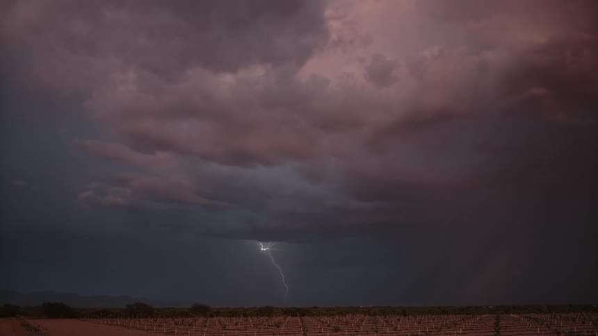 Lightning and thunder cutting through the cloudy sky at sunset