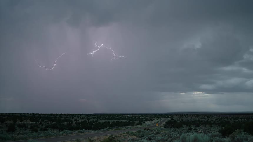 Thunderstorm over relatively flat landscape with a road