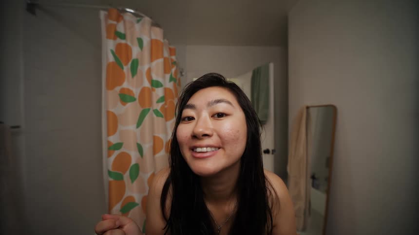 Woman checking her teeth in the bathroom mirror