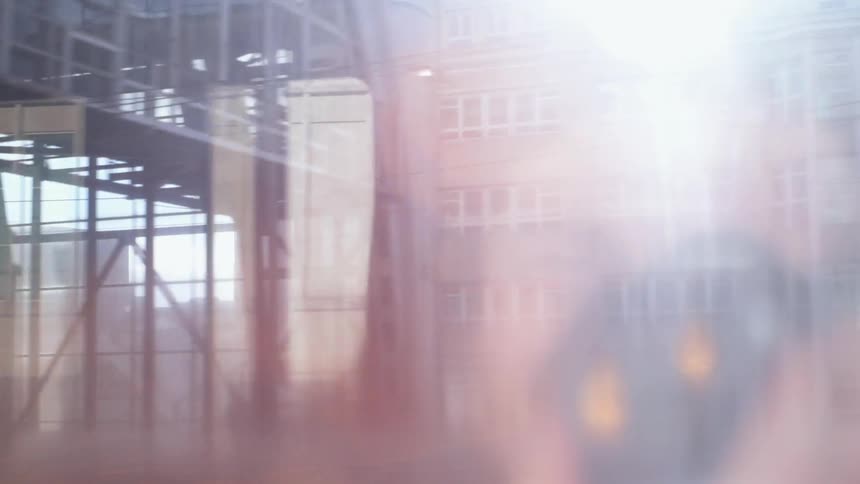 City buildings and structures are seen through the foggy window of a train
