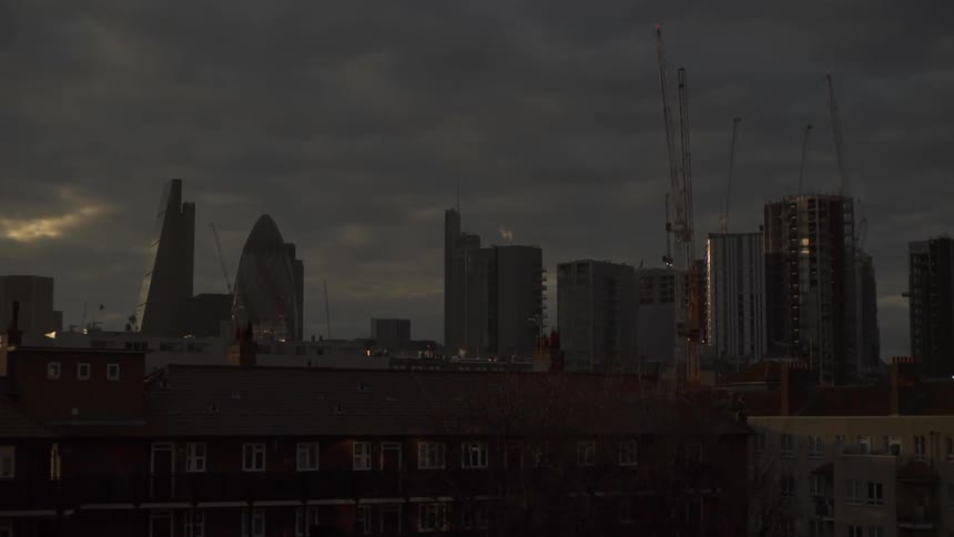 Cranes stand idle against a cloudy sky in london