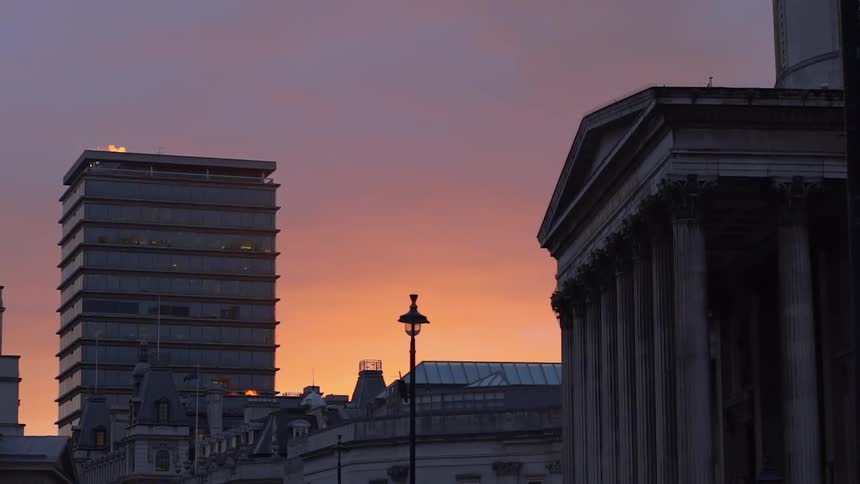 The sun is setting past these buildings