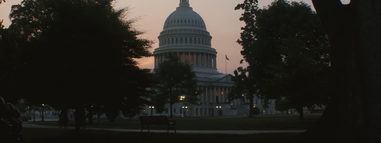 Two people ride their bicycles past capital hill