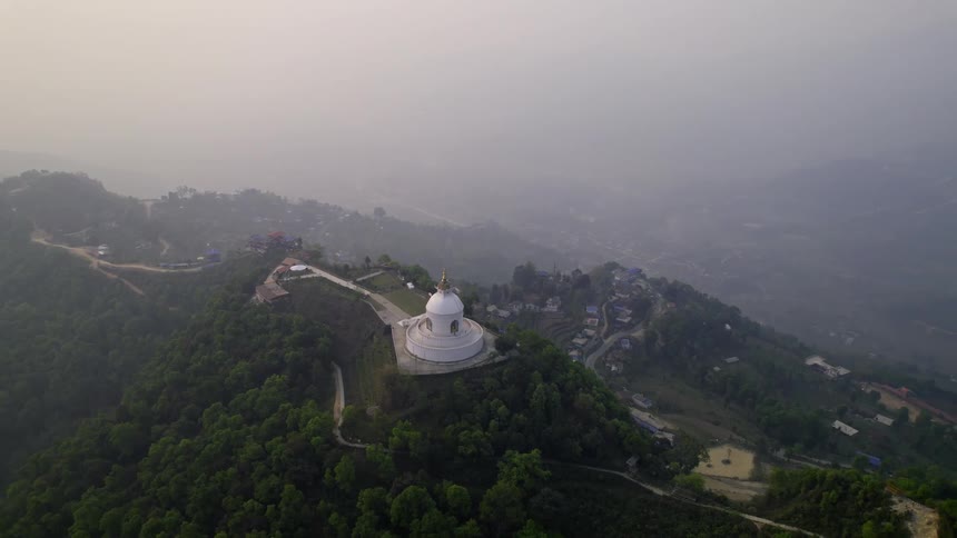 An aerial view of a tourist spot on top of the mountain surrounded by trees