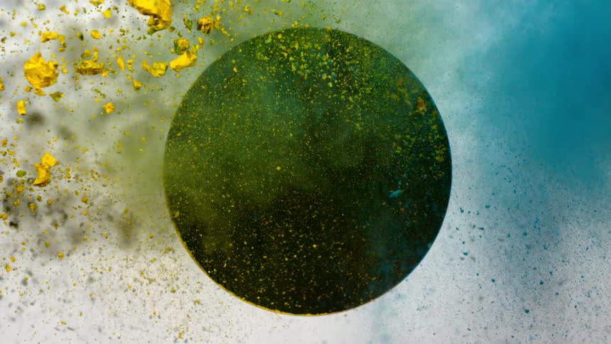 A blue dust and a yellow dust shoot through a circular hole in a panel