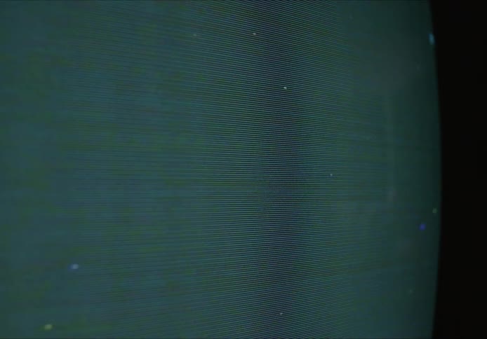 A close up of a television screen with static and pix elated images on the screen