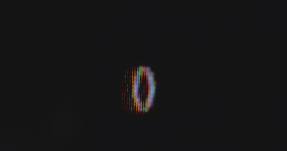 Extremely detailed handheld macro shot of display showing a round circle gauge that counts up and down from one hundred or 100 to zero or 0 in full cycles as charging or loading indicator