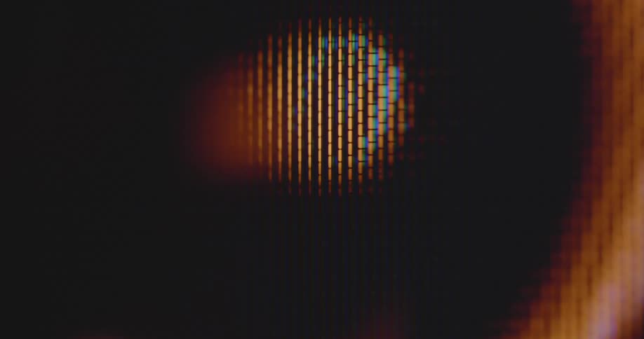 Extreme macro close up of circular orange light that flashes on and off while changing its shape in a dynamic way with movement and transformation and a line spinning around it in circles and full cycles on pixelated computer or TV screen