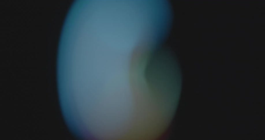 Abstract light spots out of focus in various colors representing the LGBTQ+ community movement and a society with equal rights and opportunities rotate against black background blurring into a donut shape