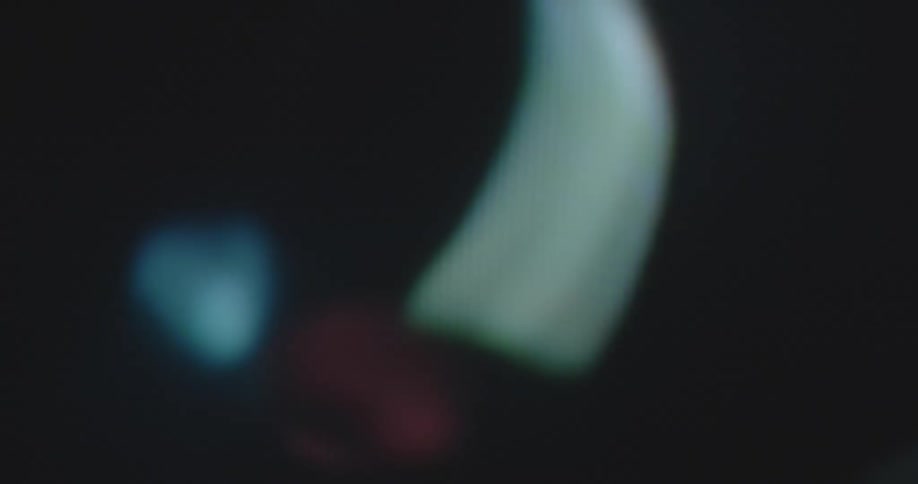 Extreme macro closeup of abstract multicolor rainbow neon lights being transformed and spinning in a circle with full cycles on a glitching digital pixelated display
