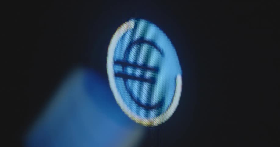 The animated EUR or € sign in the colors of the EU flag pulsates in round circle flashes transforms and moves on the television display with rgb pixels representing the European economic area