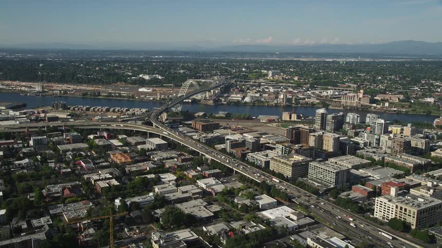 Aerial view of heavy traffic moving along Interstate 405 through Downtown Portland near the Fremont Bridge over the Willamette River in Oregon on a sunny day