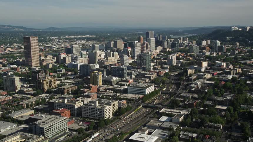 Aerial view of downtown Portland Oregon with city buildings skyscrapers and heavy traffic along Interstate 405 during a sunny day