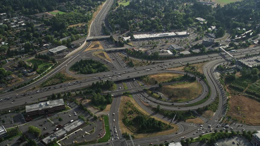 Aerial footage of traffic congestion near a freeway interchange in Southwest Portland Oregon during a sunny day