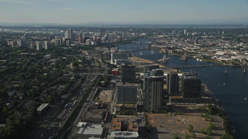 Aerial view of Downtown Portland Oregon showcasing the city's sprawl high-rise buildings river and vibrant neighborhoods during a sunny day