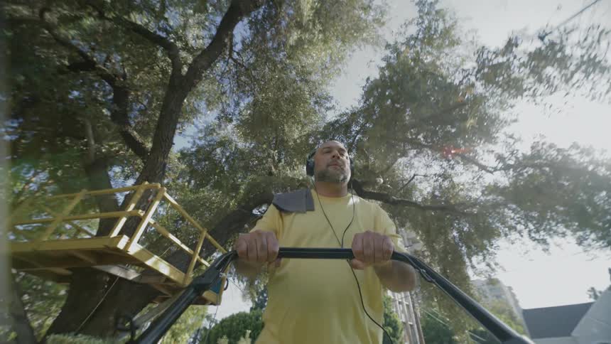 Man wearing headset and walking holding a machine with his hands