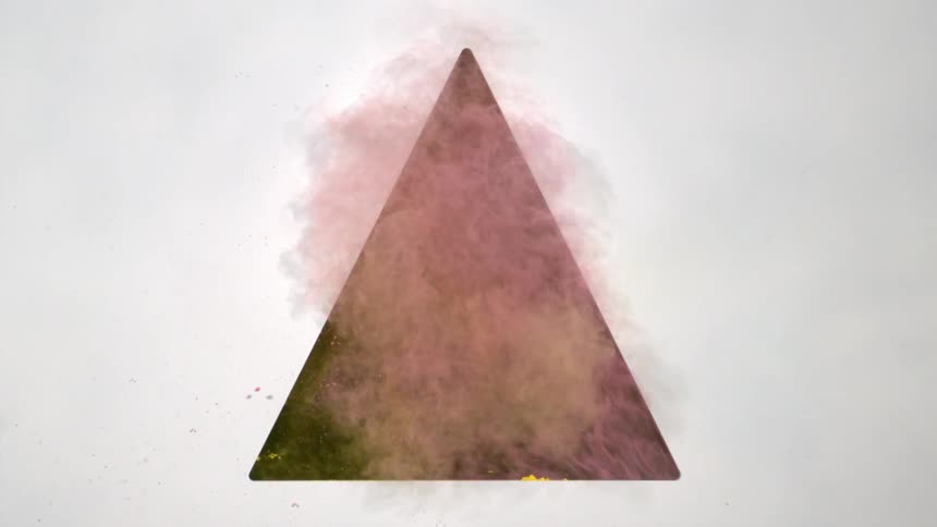 Yellow and pink powder shooting out of triangular hole in wall