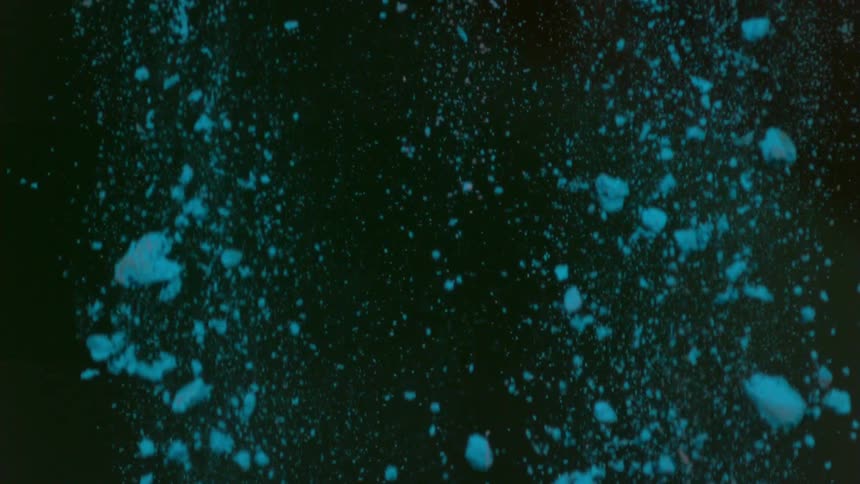 Blue clumps of powder falling