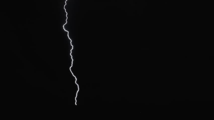 Lightning striking across the night sky lighting it up revealing clouds and utility lines